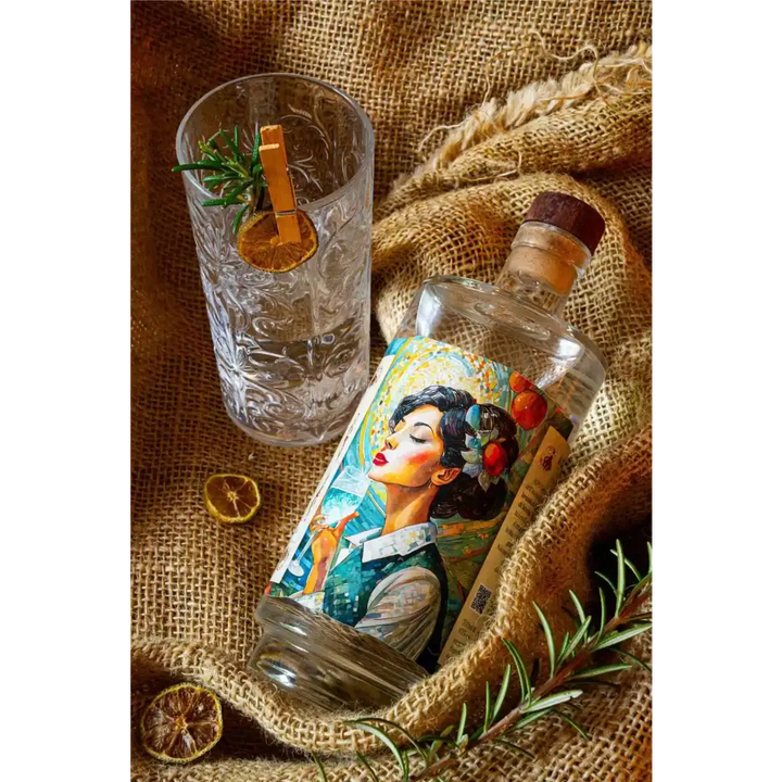 Bottiglia di AQVO Gin con etichetta colorata, limone e rosmarino come decorazioni, un gin ligure dal sapore equilibrato e aromatico.