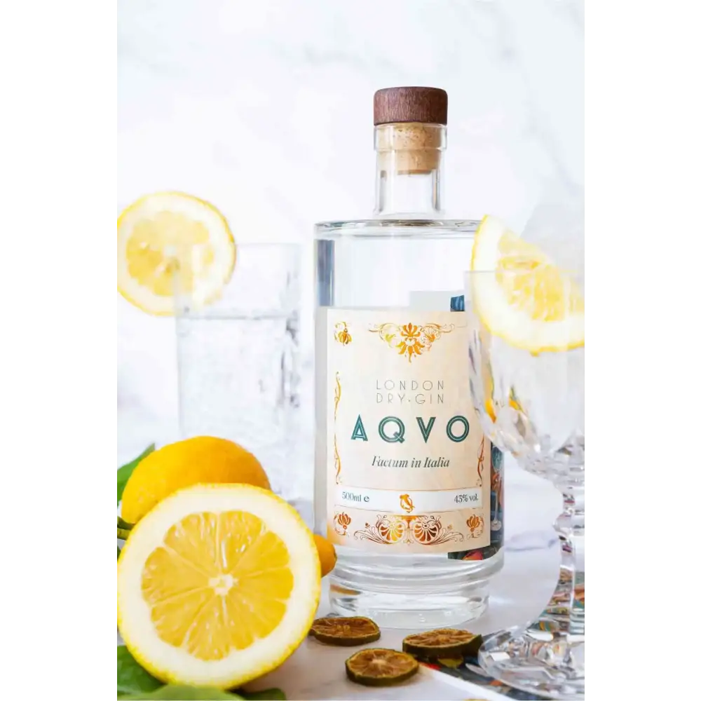 Bottiglia di AQVO London Dry Gin con limoni freschi e bicchiere, un gin artigianale italiano dal profilo aromatico agrumato e floreale